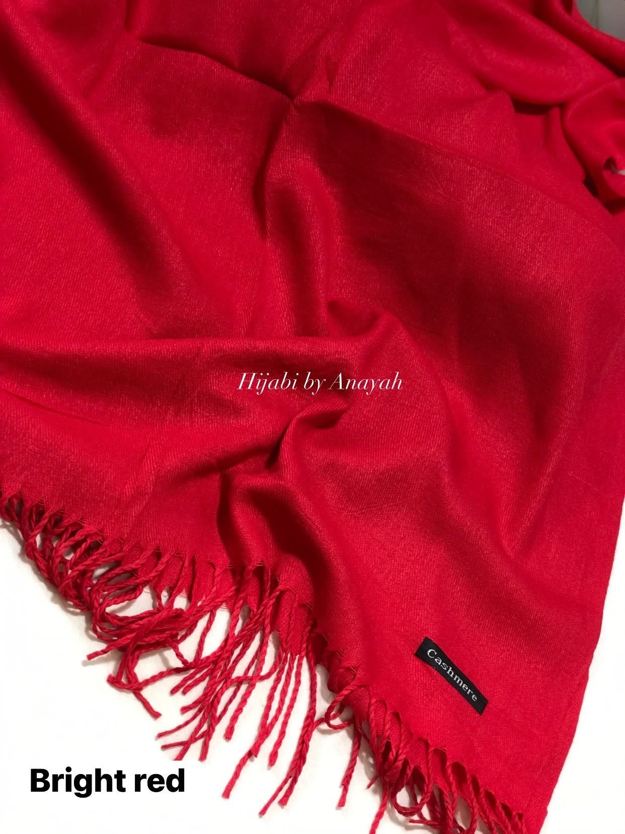 Red hijab with fringes and 'Hijabi by Anayah' branding on a white background