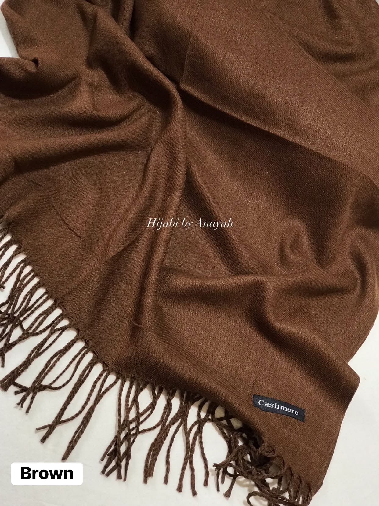Brown cashmere hijab with fringes on a white background, branded 'Hijabi by Anayah'.