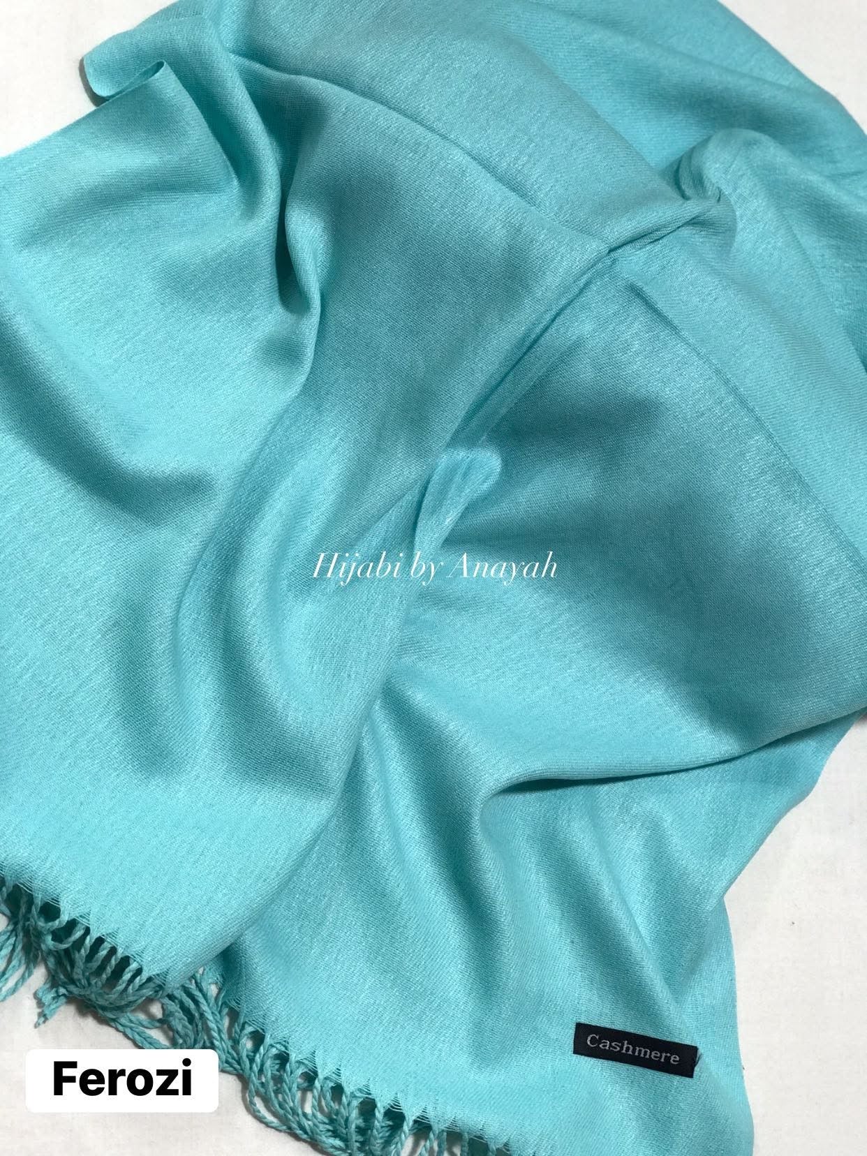 Turquoise hijab with brand labels on a white background