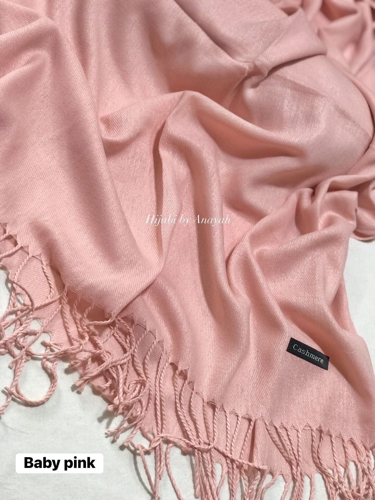Baby pink scarf with tassels on a light background