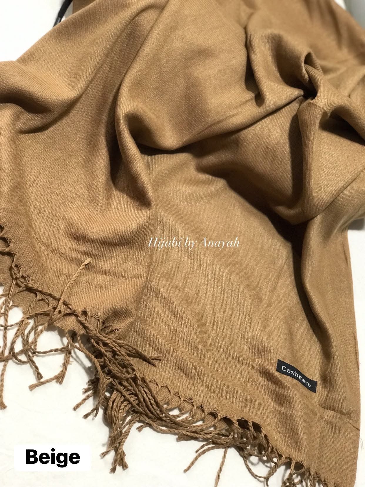 Beige hijab with fringes and 'Hijabi by Anyah' branding on a white background